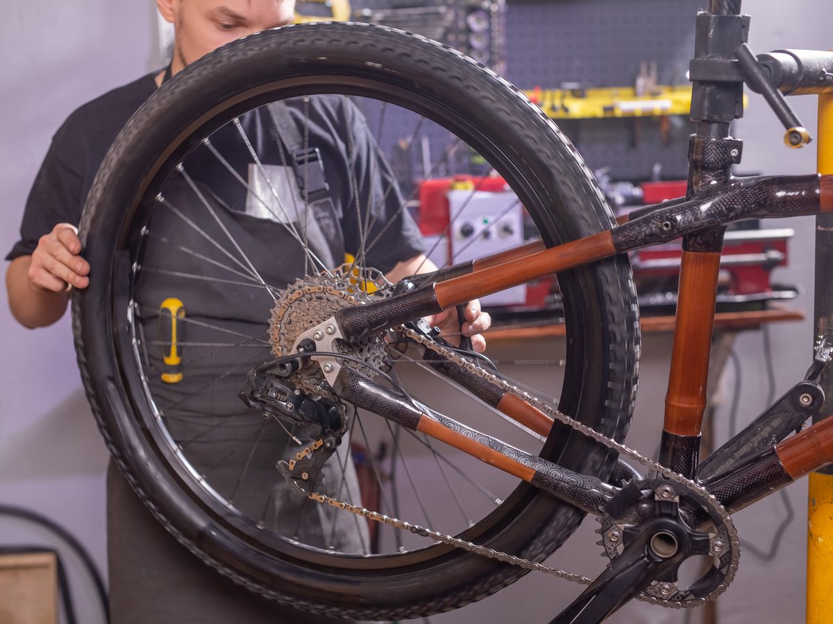A mechanic fitting the rear wheel while building up a custom bike
